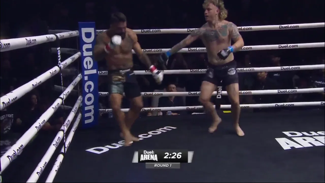 Both fighters upright in the ring at Duel Arena 1 with the round-one clock reading 2:26